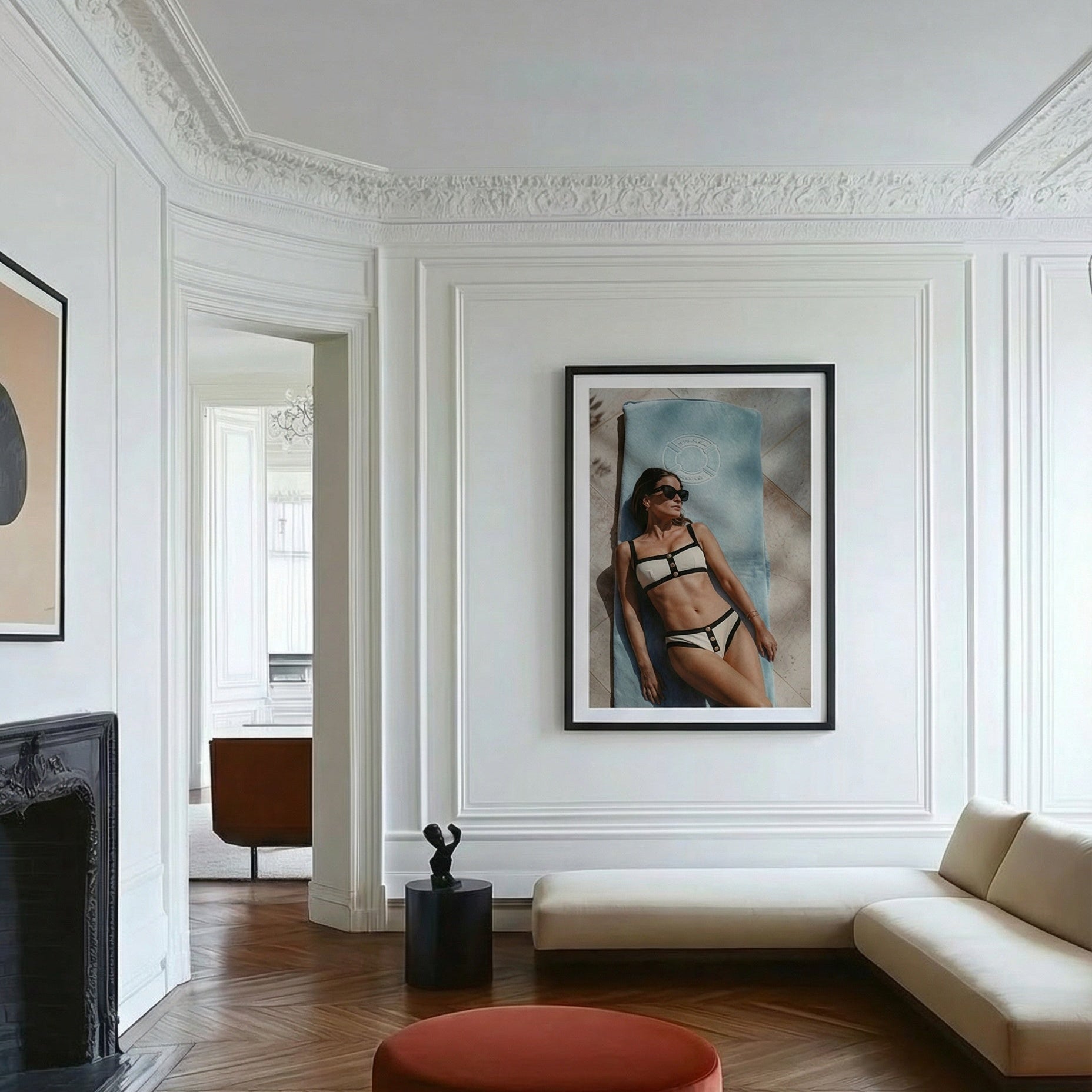 Modern living room with white walls, wooden floor, and a framed picture of a woman in a bikini.