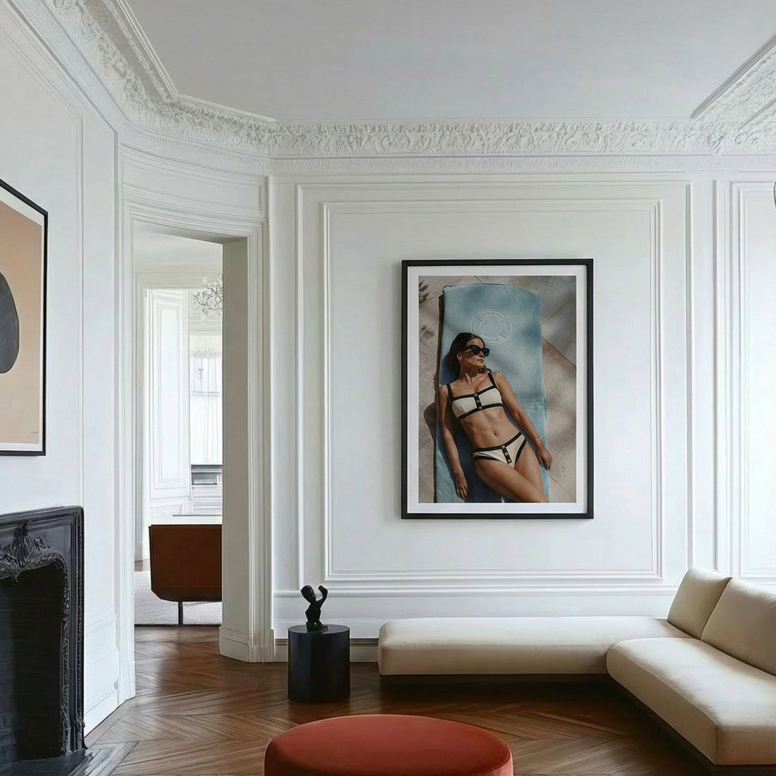 Modern living room with white walls, wooden floor, and a framed picture of a woman in a bikini.