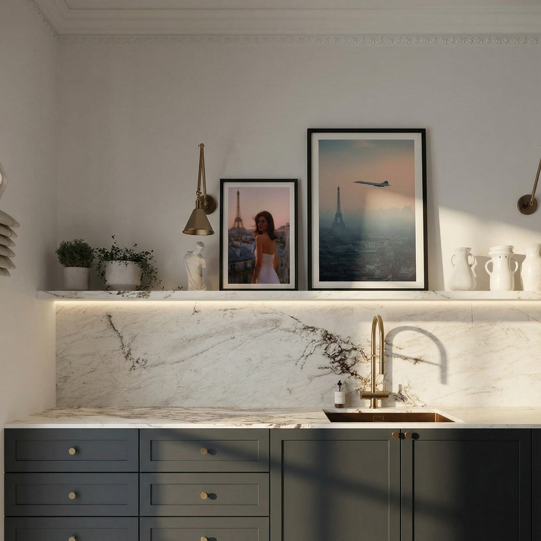 Modern kitchen with dark green cabinets, marble countertop, and framed pictures on the wall.