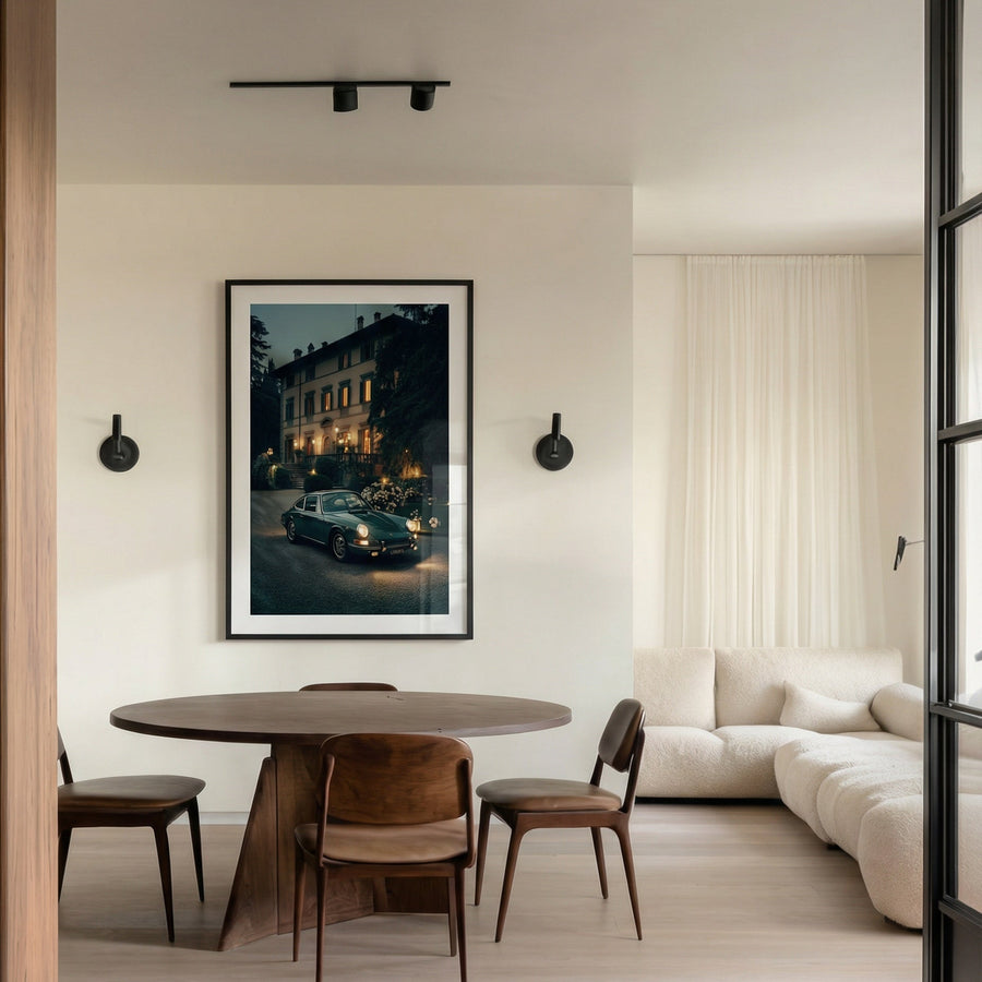 Modern living room with a round dining table and chairs, white sofa, and framed picture on the wall.