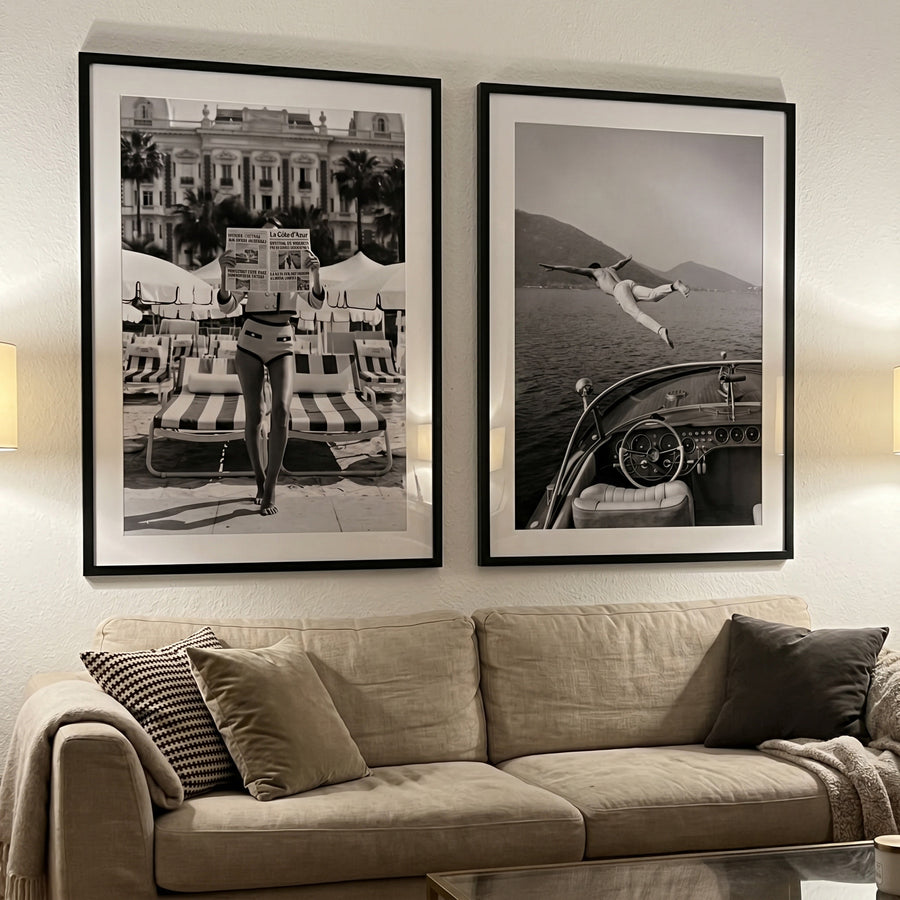 Two framed black and white artworks on a wall above a sofa.